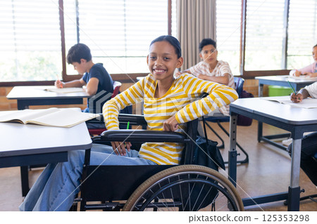 In school, girl in wheelchair smiling and studying with classmates in classroom In school, girl in wheelchair smiling and studying with classmates in classroom 125353298