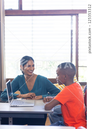 Indian female teacher and student using laptop in classroom, engaging in school, copy space Indian female teacher and student using laptop in classroom, engaging in school, copy space 125353312