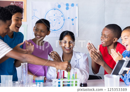 In school, students clapping and smiling with Indian female teacher in science classroom In school, students clapping and smiling with Indian female teacher in science classroom 125353389