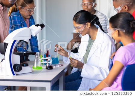 In school, students conducting science experiment with test tubes and microscope 125353390