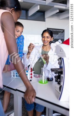 Conducting science experiment with test tubes and beakers, students in school laboratory 125353393