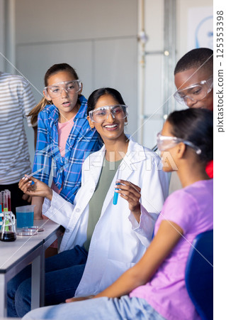 In school, students conducting science experiment with test tubes and safety goggles 125353398