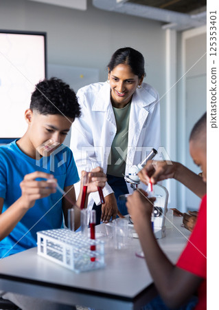 In school, students conducting science experiment with test tubes and microscope 125353401