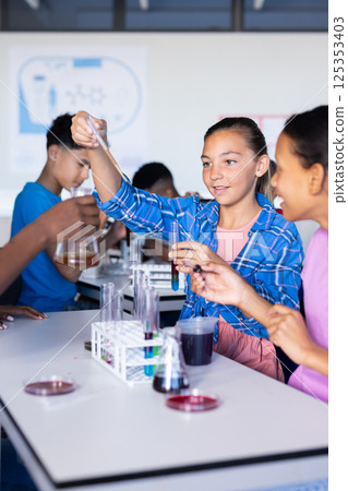 In school, students conducting science experiment with test tubes in classroom In school, students conducting science experiment with test tubes in classroom 125353403