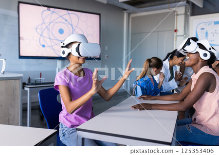 Using VR headsets, students in school classroom exploring virtual reality together Using VR headsets, students in school classroom exploring virtual reality together 125353406