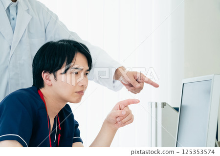 Male doctors looking at data and discussing 125353574