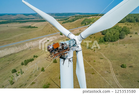 Aerial shot of wind turbine with fire damage in a rural landscape during the daytime Aerial shot of wind turbine with fire damage in a rural landscape during the daytime 125353580