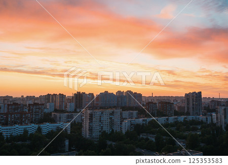 Sunset over urban landscape with vibrant colors illuminating buildings in city skyline Sunset over urban landscape with vibrant colors illuminating buildings in city skyline 125353583