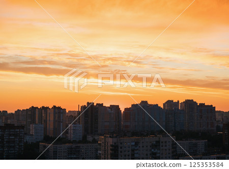 Vibrant city skyline during sunset with colorful clouds reflecting over urban buildings Vibrant city skyline during sunset with colorful clouds reflecting over urban buildings 125353584