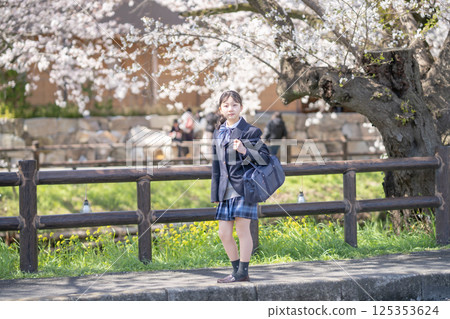 A female student in uniform under the cherry blossoms 125353624