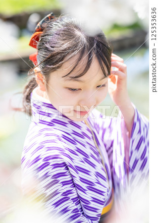 A female student wearing a hakama under the cherry blossoms 125353636