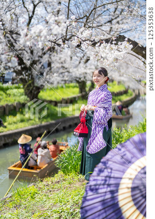 A female student wearing a hakama under the cherry blossoms A female student wearing a hakama under the cherry blossoms 125353638