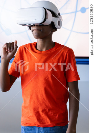 Using VR headset, boy in school exploring virtual reality experience Using VR headset, boy in school exploring virtual reality experience 125353980