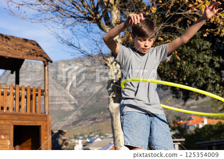 Playing with hula hoop, boy enjoying outdoor activity at school playground Playing with hula hoop, boy enjoying outdoor activity at school playground 125354009