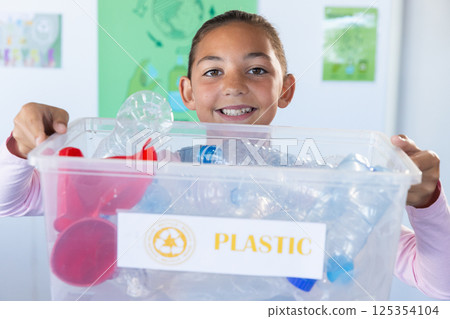 Holding recycling bin, smiling girl participating in school recycling program Holding recycling bin, smiling girl participating in school recycling program 125354104