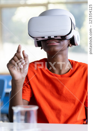 Using VR headset, student in school exploring virtual reality in classroom 125354125