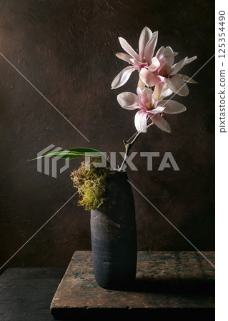 Elegant Magnolia Flowers In Dark Vase 125354490