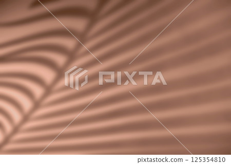 Shadow of palm leaf on natural earthy mocha mousse color background 125354810