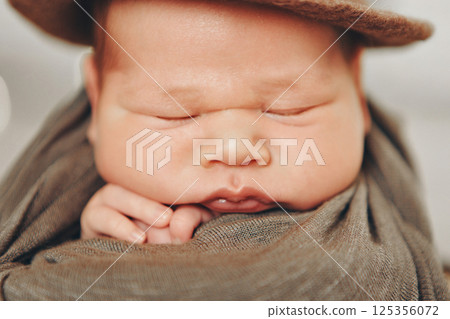 A newborn baby is wrapped in diapers with a wool cap in a basket. Swaddling, maternity hospital, family, ivf, life planning, parenting. A mother's love for her child. Baby food. High quality photo A newborn baby is wrapped in diapers with a wool cap in a basket. Swaddling, maternity hospital, family, ivf, life planning, parenting. A mother's love for her child. Baby food. High quality photo 125356072