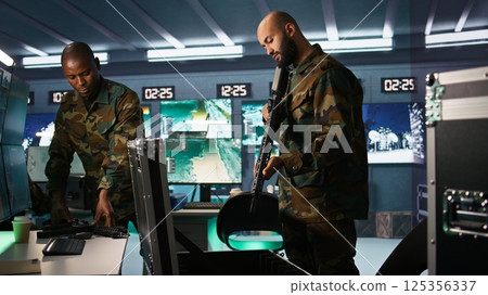 Army soldiers packing weapons able to engage targets at extended range with accurate, lethal fire. Military units loading guns with bullets, preparing for enemy suppression mission, camera B Army soldiers packing weapons able to engage targets at extended range with accurate, lethal fire. Military units loading guns with bullets, preparing for enemy suppression mission, camera B 125356337