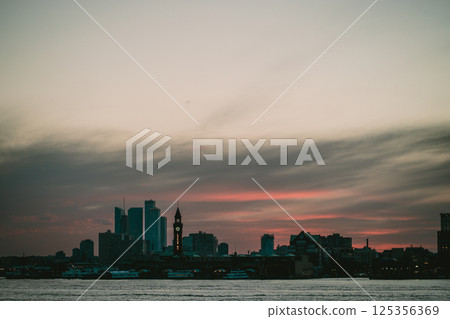 A blurry photograph showcasing a picturesque city skyline during sunset 125356369