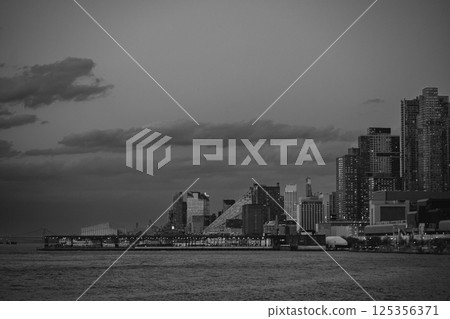 A black and white photo of a skyline over a body of water A black and white photo of a skyline over a body of water 125356371