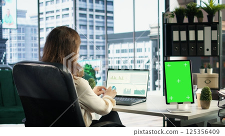 General director using chroma key template on modern gadget, developing her business within the industry. Female entrepreneur with ambition in her high end corporate office. Camera A. General director using chroma key template on modern gadget, developing her business within the industry. Female entrepreneur with ambition in her high end corporate office. Camera A. 125356409