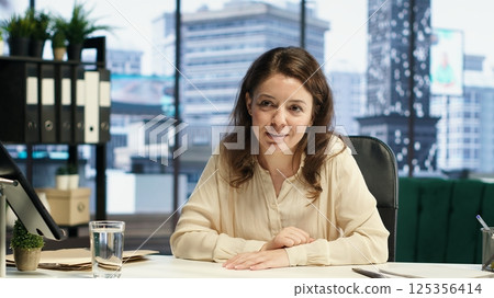 Successful inspirational female leader sharing her business goals and targets with the advisory board, discussing with partners on videocall about new funds for strategy. Leadership skills. Camera A. 125356414