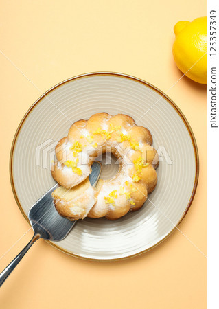 Lemon cake on plate and lemon on beige background, top view 125357349