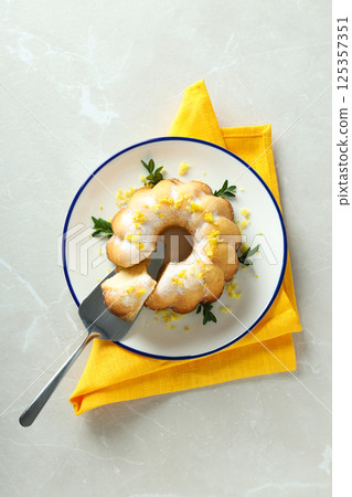 Lemon cake on plate and towel on gray background, top view Lemon cake on plate and towel on gray background, top view 125357351