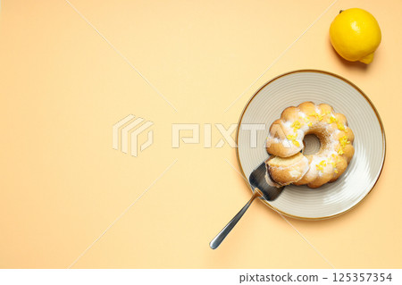 Lemon cake on plate and lemon on beige background, space for text 125357354