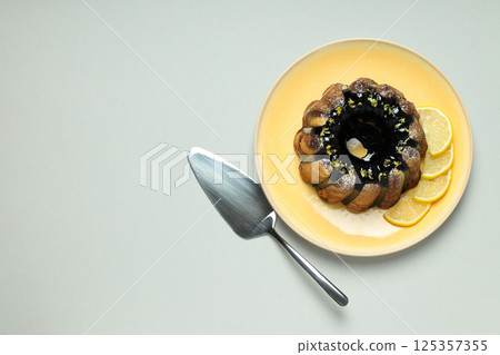 Lemon cake and sliced lemon on plate on gray background, space for text 125357355