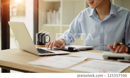 Close up of business analyst calculating financial data at desk Close up of business analyst calculating financial data at desk 125357390