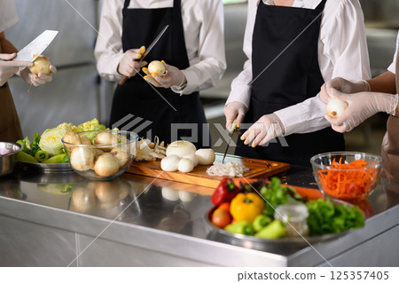 Students peeling and slicing onions during a hands-on culinary training session 125357405