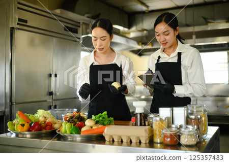 Female student learning food preparation techniques in cooking class Female student learning food preparation techniques in cooking class 125357483