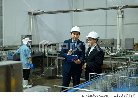 Two business professionals reviewing operations in a food production facility Two business professionals reviewing operations in a food production facility 125357487
