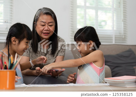 Back to School and Family Learning. A grandmother supporting her granddaughters in hands-on educational activities. Back to School and Family Learning. A grandmother supporting her granddaughters in hands-on educational activities. 125358125