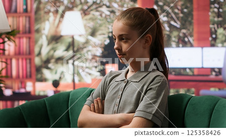 Adolescent girl in therapy discussing behavioral issues and personal challenges. Counseling session with psychologist to help with intrusive thoughts, improve overall emotional wellbeing. Camera A. 125358426