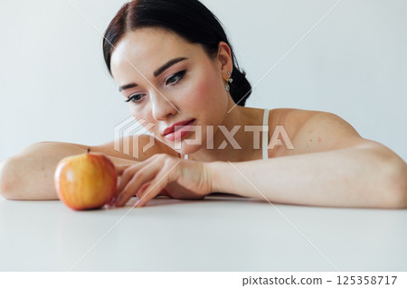Brunette wants to eat a red apple for a diet Brunette wants to eat a red apple for a diet 125358717