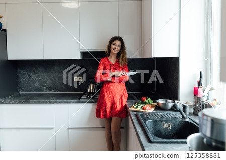 Woman in dress with knife for cooking in kitchen 125358881