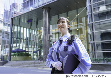 A young female security guard standing in front of an office building. Photo courtesy of Tokyo Electronics College, Denpa Gakuen Corporation. A young female security guard standing in front of an office building. Photo courtesy of Tokyo Electronics College, Denpa Gakuen Corporation. 125359470