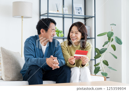 一對中年夫婦在客廳看著他們的存摺 125359934