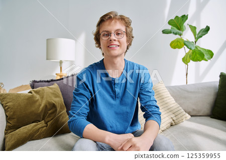 Webcam portrait male student teenager with glasses, sitting at home Webcam portrait male student teenager with glasses, sitting at home 125359955