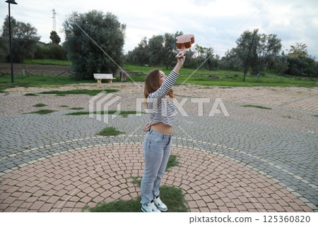 Girl Makes Bow After Playing Ukulele Instrument In A Park 125360820