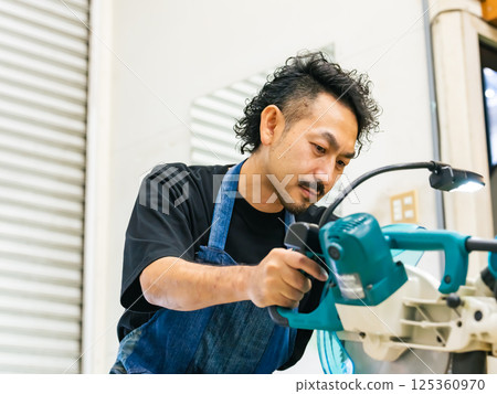 Male craftsman using an electric saw DIY Male craftsman using an electric saw DIY 125360970