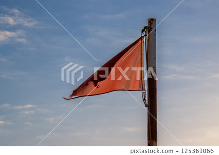 Red flag on a beach and blue sky, Spain 125361066