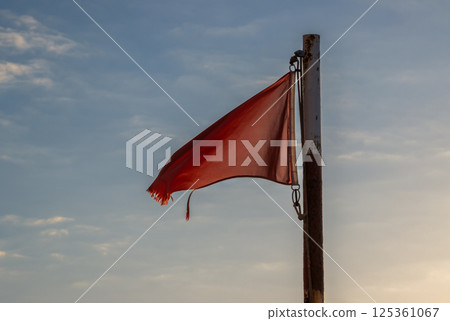 Red flag on a beach and blue sky, Spain 125361067