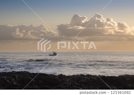 Atlantic ocean with a boat, golden hour, Spain Atlantic ocean with a boat, golden hour, Spain 125361092