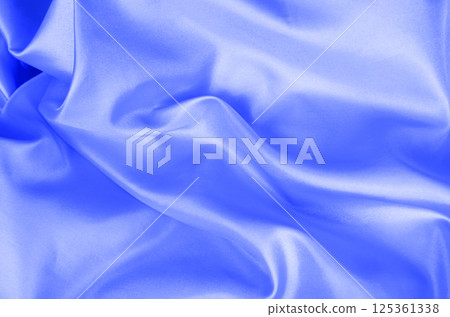 Top view of light blue color silk in soft, smooth waves with a glossy finish. Suitable for design and wallpaper background. Top view of light blue color silk in soft, smooth waves with a glossy finish. Suitable for design and wallpaper background. 125361338