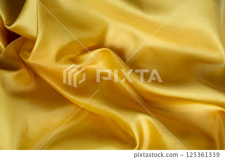Top view of dark yellow satin fabric with a glossy finish. Suitable for design and wallpaper background. 125361339